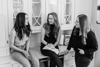 Black and white image of JaCee Petko, Christian life coach, talking to 2 other women and holding her Bible