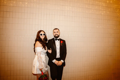 An eloping couple poses on Fremont street at night.