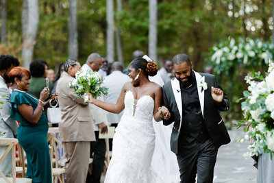 bride and groom dance down the aisle of their wedding styled by a Raleigh NC wedding planner