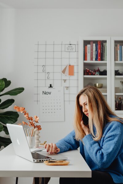 Man sitting in a chair at a table working from home at a laptop