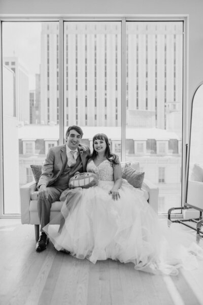 Couple sitting by large window in black and white