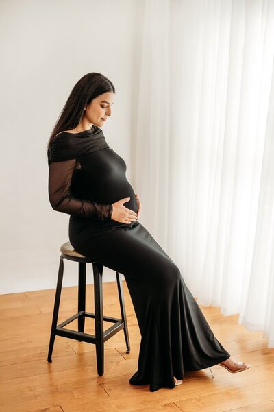 studio maternity photo of mom in red two piece maternity dress