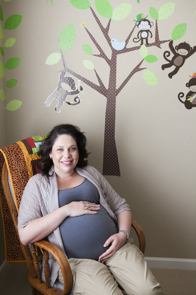 Pregnant mother sitting in rocking chair in her new nursery.