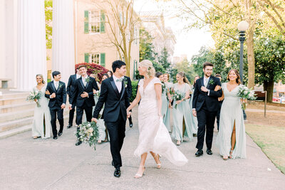 Bridal party walking outside with bride and groom in front