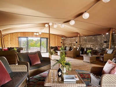 The terrace area of Polhawn Fort with a. stretch marquee and lounge furniture set up underneath the canpoy