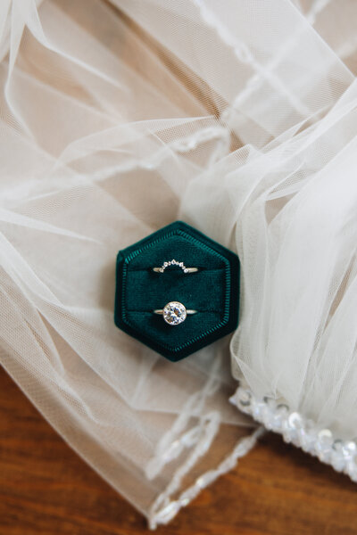 Wedding rings lay on a veil.