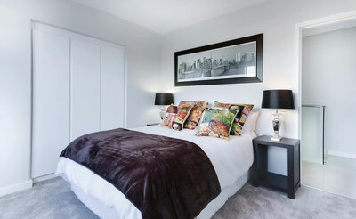 Clean bedroom with white and brown linens