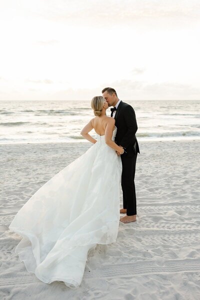 Couple kissing on a beach taken by one of the top wedding photographers naples fl has to offer