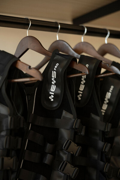 State-of-the-art EMS equipment on hangers, highlighting the tools used for fast and efficient 20-minute sessions.