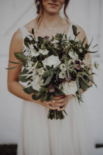 mariée portant un gros bouquet de fleurs