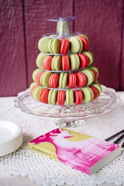 An author’s book is placed on a table adjacent to a delightful stack of macarons, reflecting a sophisticated website design.