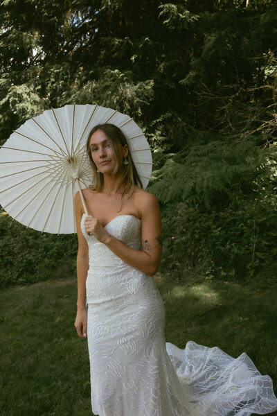Bride stands with parasol umbrella