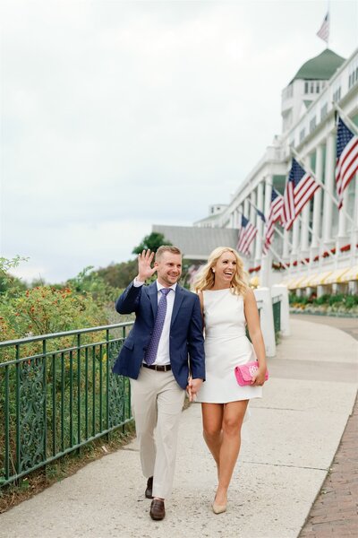 Bride and Groom at their welcome party, standing in front of the Grand Hotel on Mackinac Island and waving to guests