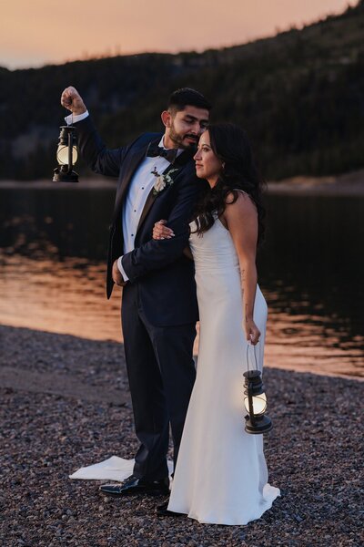 Bride and groom stand near alpine lake during Breckenridge elopement.