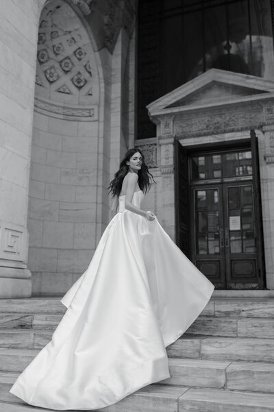 black and white image bride wearing strapless satin wedding dress with long train