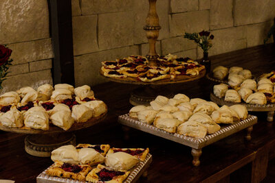 Tartes and scones displayed on multiple platters on a wood table