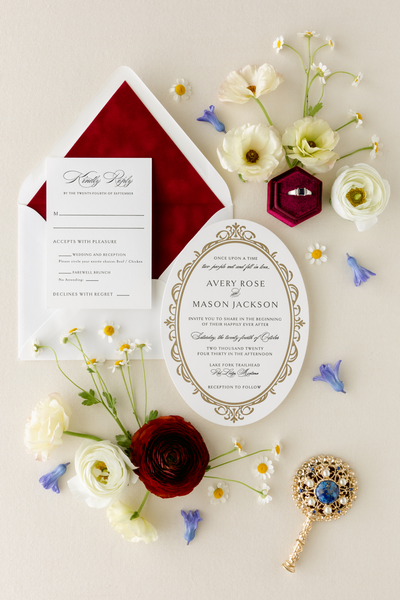 Polished oval letterpress wedding invitation featuring intricate gold accents paired with a luxurious red velvet envelope liner, offering refined and sophisticated invitation ideas for a memorable celebration.
