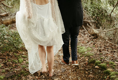 couple walking together in the woods during their elopement in eagle river, Alaska