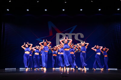 competitive dancers posing on stage at competition