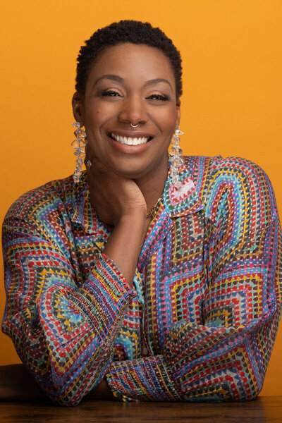 Professional headshot woman with gold background