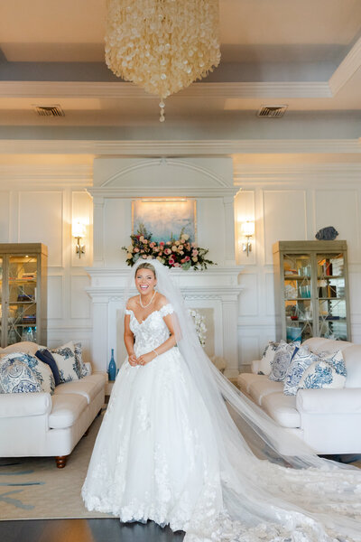 Bride holding a white and yellow bridal bouquet, in front of a window before her wedding in Alabama