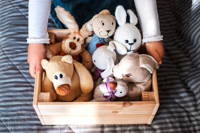 Various bears, bunnies, and animal stuffed animals in a wooden box