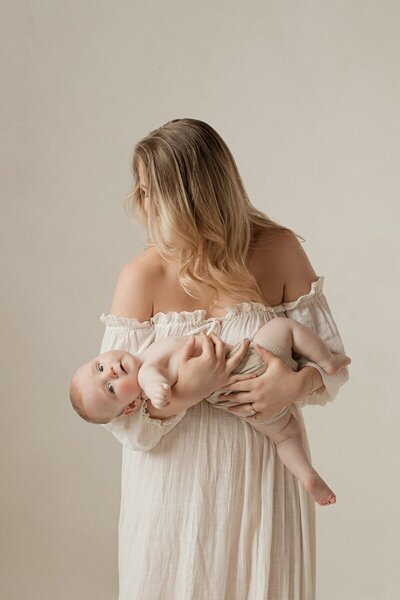 Mother holding newborn in natural light captured by a Michigan photographer