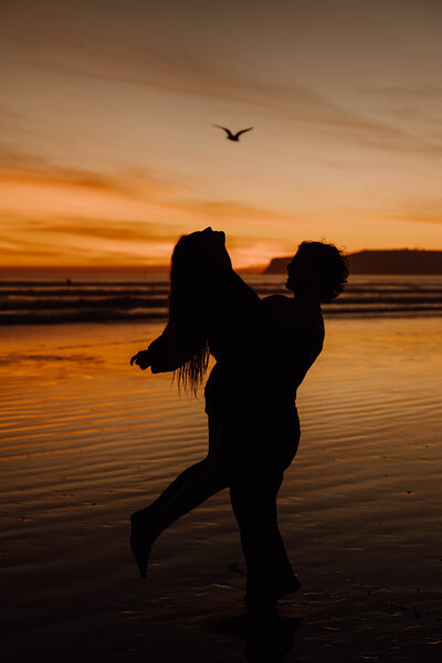 silhouettes of two people at sunset