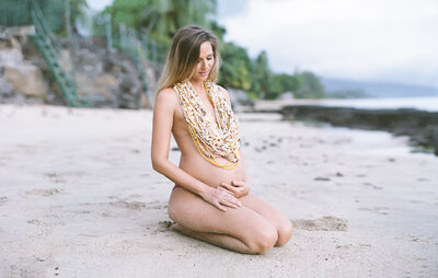Maman enceinte habillée de coquillages sur la plage