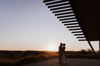 Couple standing underneath the arched building at Levantine Hill Yarra Valley by Ada and Ivy wedding photography