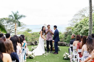 Newlyweds laughing with their officiant during their wedding ceremony 