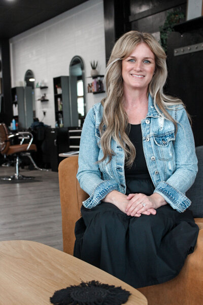 A girl sitting on a couch in the waiting area of a salon