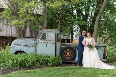 Bride and Groom posed in front of truck on the Country Strong grounds.