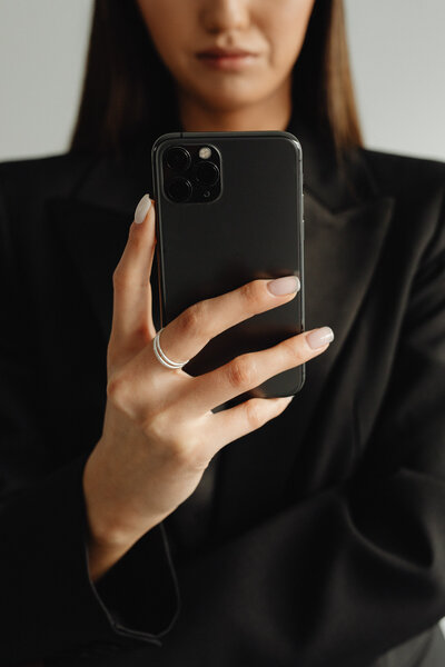 Woman holding up her cell phone to take a picture.