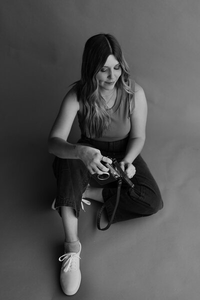 a girl holding a camera in a studio