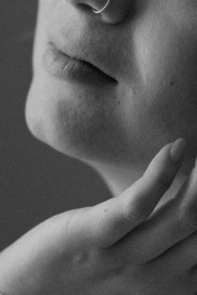 close up of woman's hand touching her face