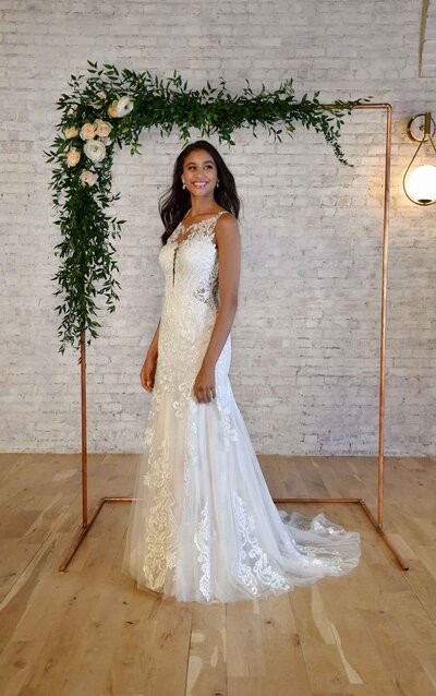 GARDEN-INSPIRED OFF-SHOULDER WEDDING GOWN Garden beauties, meet your match. This wedding gown from Stella York has it all for the botanical-inspired princess bride! With an overall lightweight feel, this gown offers a modern alternative to traditional lace styles. The sweetheart neckline is youthful and feminine on its own as a strapless style, or you can amp up the princess vibe with the detachable organic lace straps! Large-scale embroidered laces feature various organic shapes throughout the bodice, and increase in size as they fall over the waistline and throughout the A-line skirt for a windswept effect. The laces also feature delicate sequin detailing throughout the embroidery, producing a dew-like shimmer to enhance your natural glow! Horsehair finishing keeps the skirt feeling fresh and lightweight, while maintaining a full shape. A very slight train follows behind the silhouette for a touch of traditional style and all of the manageability. This gown is also available in plus sizes.