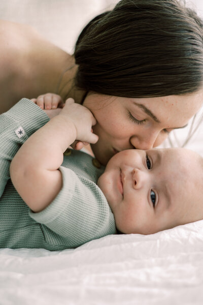 An intimate moment between mom and baby as she kisses his cheek.