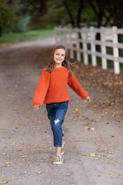 Little girl skipping down a path during child photography with Tiffany Hix