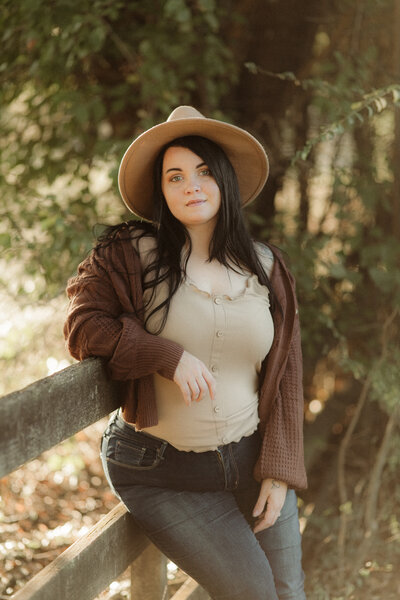 Woman leaning against a fence at sunset by Atlanta Motherhood Photographer