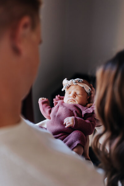 Nashville newborn photographer captures studio portraits of baby in purple outfit