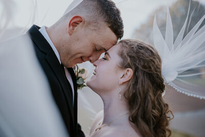 Destination wedding photographer captures couple embracing under a wedding veil at a nashville wedding