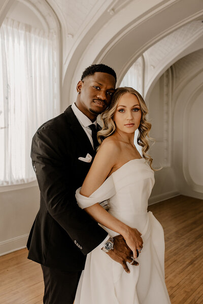 Bride and groom celebrate their elegant luxury wedding at the historic Cottonwood Hotel in Omaha, NE – timeless moments captured by Tori Nichole Photography. A perfect blend of sophistication, romance, and architectural charm, showcasing the couple's love story in an unforgettable setting.