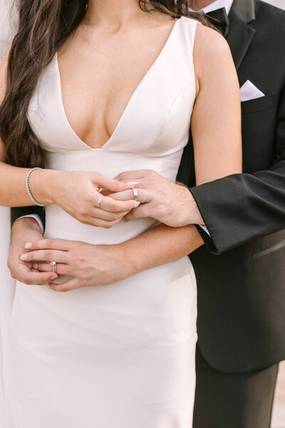 Details of the couple holding hands and playing with their wedding rings