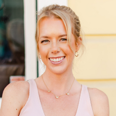 Blonde fair skinned woman smiling with yellow background