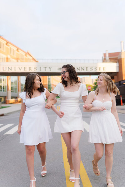 three girls walk down phillip fulmer way on the university of tennessee knoxville campus