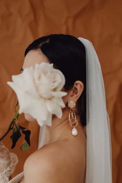 a bride wearing a veil holding a flower