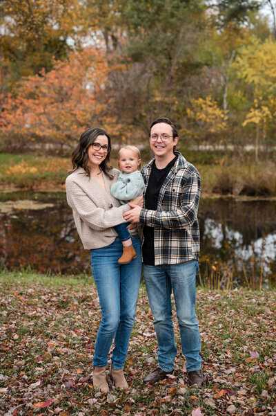 Family posing in front of a pond