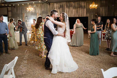 Bride and groom dancing surrounded by wedding guests