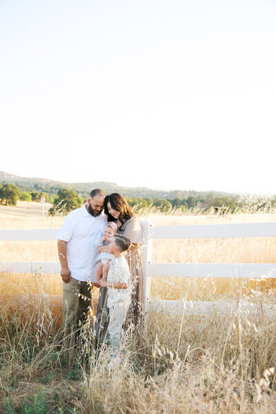 family playin on the rocks together with the lake in the background taken by maternity photographer sacramento Kelsey Krall